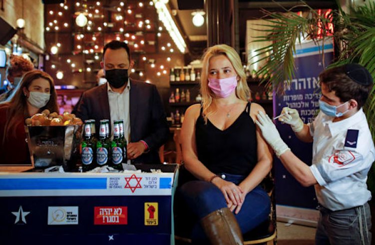 אשה מקבלת חיסון בפאב בתל אביב